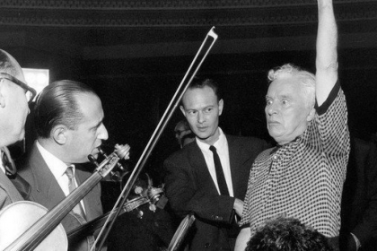 L'homme qui lève le bras, c'est Charles Chaplin. Sur la photo, il est en train de diriger les musiciens pour l'enregistrement de la musique de son film Un Roi à New York le 21 juin 1957 au Palais de la Mutualité à Paris. (© Rue des Archives/AGIP)