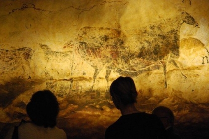 Sur cette photo, tu peux voir des visiteurs qui admirent une reproduction des peintures de la grotte de Lascaux lors de l'exposition "Lascaux 3", à Chicago. (© AFP PHOTO / Mira OBERMAN)