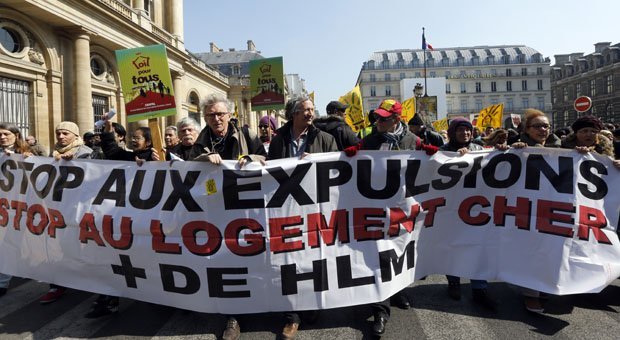 Sur cette photo, tu peux voir des gens qui manifestent contre les expulsions. Sur la banderole, tu peux lire : "Stop aux expulsions, stop au logement cher, plus de HLM." Avec la fin de la trêve hivernale, des milliers de personnes risquent d'être expulsées de leur logement car elles n'ont pas assez d'argent pour payer leur loyer. (© AFP PHOTO/PIERRE VERDY)