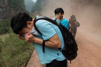 Les deux garçons que tu vois sur cette photo protègent leur visage de la poussière des chutes de pierre provoquées par le tremblement de terre. (© CHINA OUT AFP PHOTO)