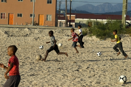 Enfants sud-africains jouant au foot.