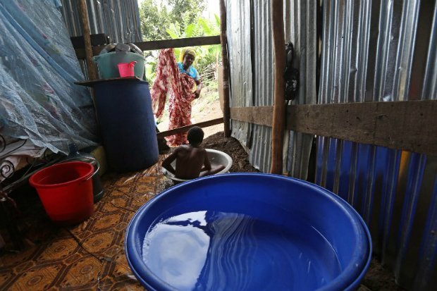 Dans l'île française de Mayotte, outre-mer, un enfant se lave dans la cabane qu'il habite avec sa famille, dans un bidonville. (RICHARD BOUHET AFP)