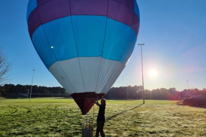 Hamish prépare sa montgolfière avant de la faire voler : il démêle les cordes, déplie la toile, gonfle le ballon…