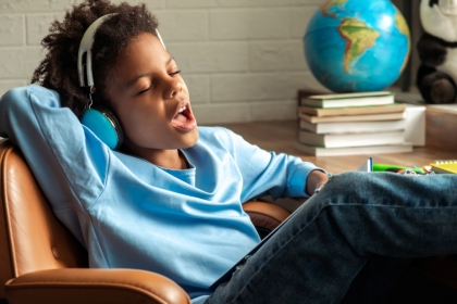 Enfant qui chante en faisant ses devoirs.