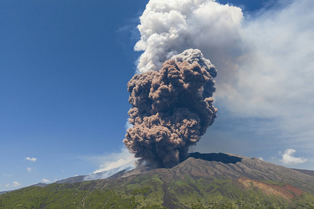 Photo montrant un épais nuage de fumée grise s'échappant du cratère de l'Etna.