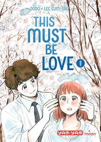 Couverture du manga 'This Must Be Love' montrant un jeune homme ajustant les écouteurs d’une jeune femme, sur un fond de branches d’arbres nues.