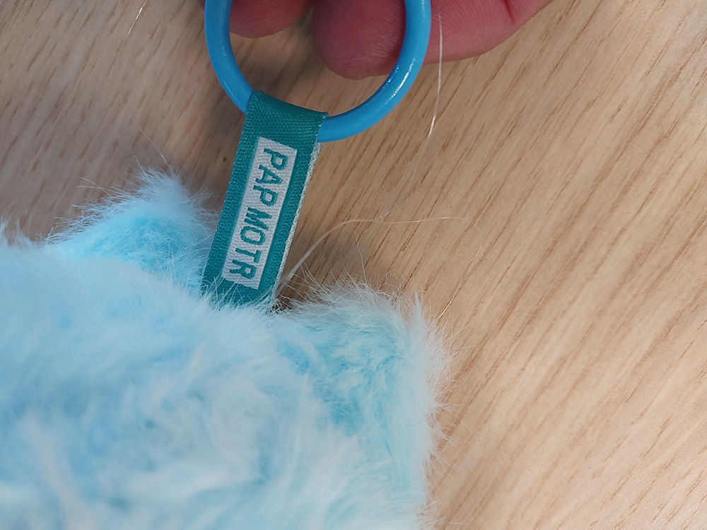Photo de l'étiquette d'une fausse peluche Labubu avec des fautes. Est inscrit "PAP MOTR"