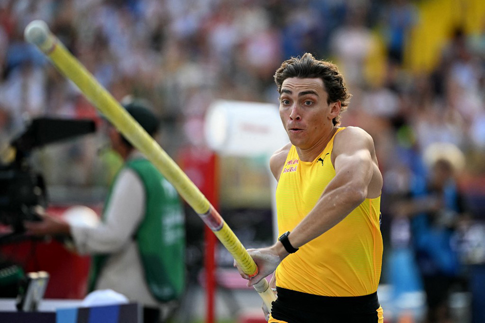 Armand Duplantis prenant son élan, la perche à la main. 
