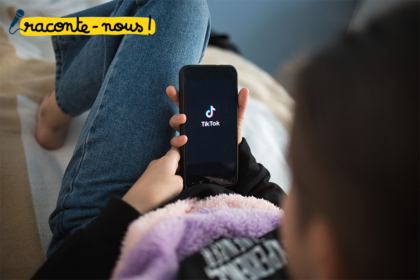 Photo d'un enfant de dos regardant TikTk dans son canapé
