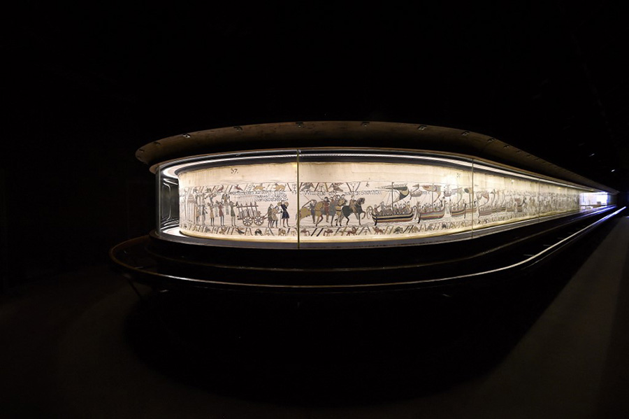 Photo de la tapisserie de Bayeux sous sa vitrine de verre.