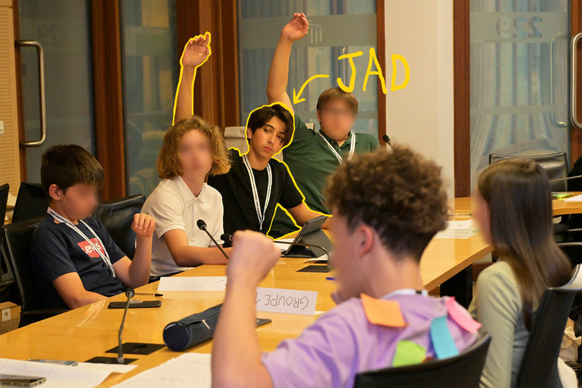 Photo d'ados à une table officielle du CESE avec micros intégrés. Certains lèvent la main pour prendre la parole. C'est le cas de Jad